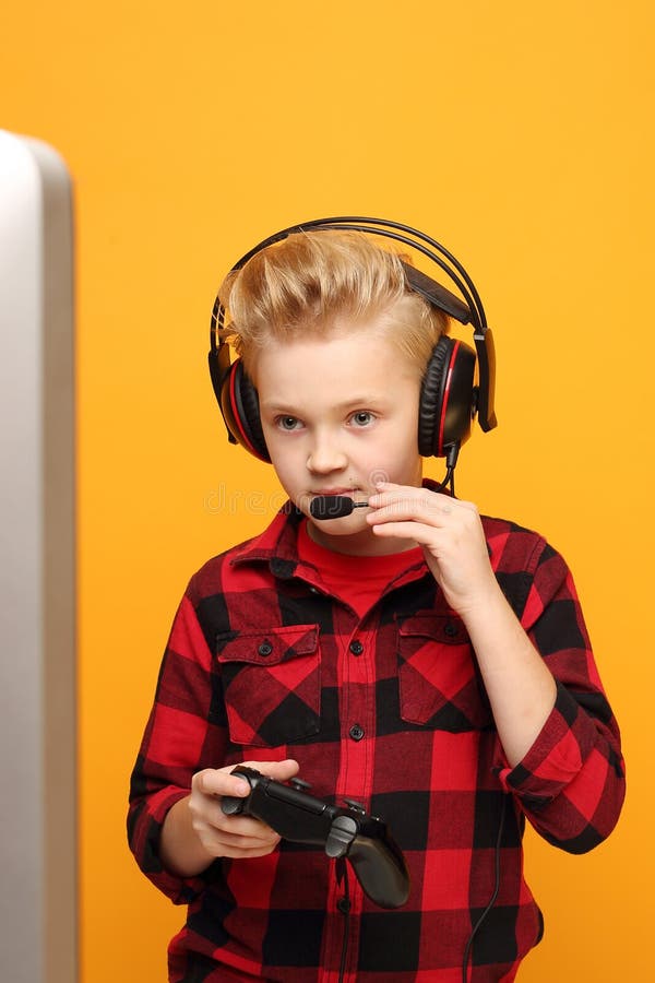 Datorspel online En ung pojke spelar på konsolen med hörlurar fotografering för bildbyråer
