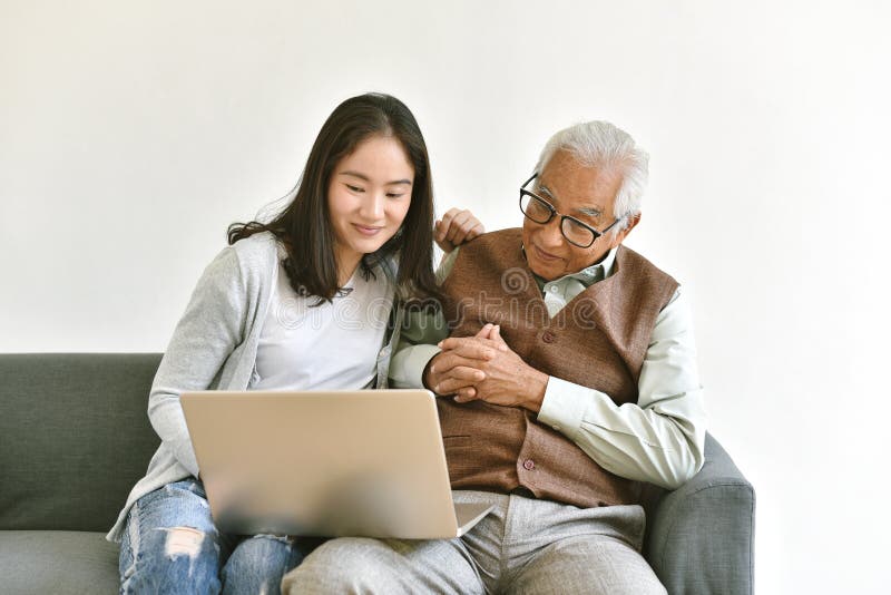 Daughter and elderly father using laptop computer together, Senior people spend time learning to use social media and digital. stock image