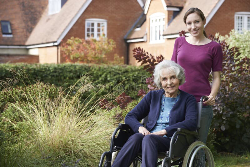 Daughter Pushing Senior Mother In Wheelchair stock image Daughter Pushing Senior Mother In Wheelchair stock image