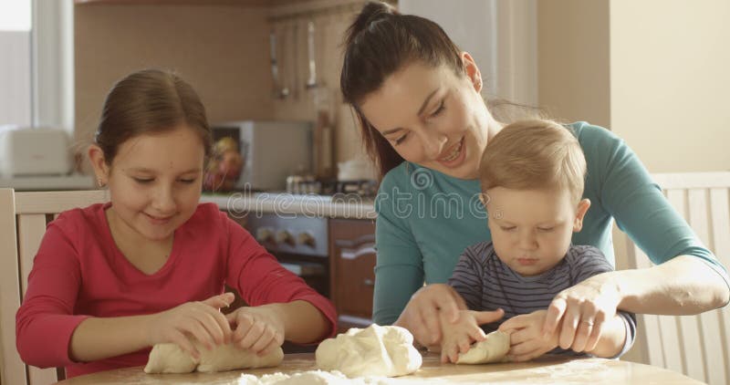 Daughter and Son Helping Mother to Cook Kneading Dough in the Kitchen and Family Spending Time Together