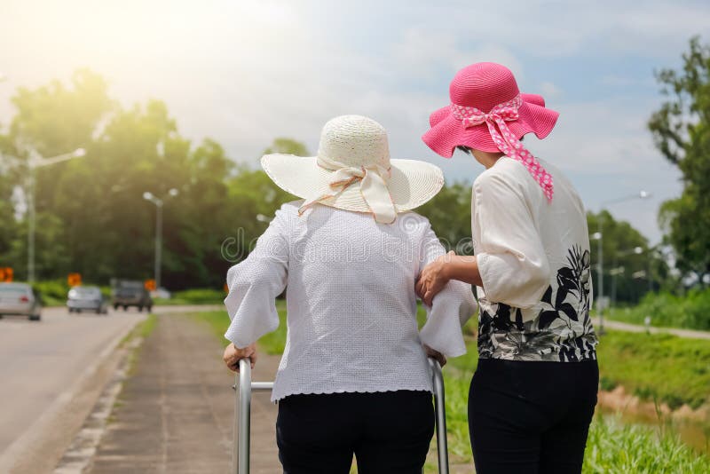 Prendere cura più vecchio donne sul strade forte luce del sole.