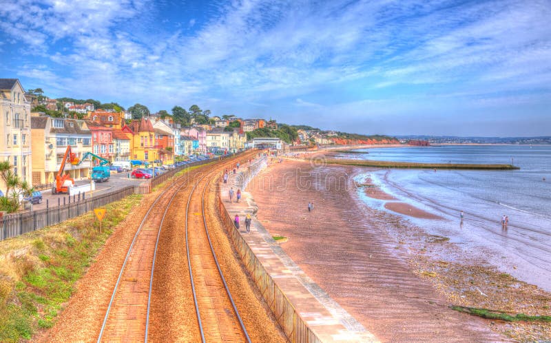 Dawlish Devon Αγγλία με τη διαδρομή σιδηροδρόμων παραλιών και θάλασσα τη θερινή ημέρα μπλε ουρανού σε HDR