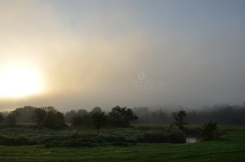 Dawn onderbrekingen over een weilandkreek in FingerLakes royalty-vrije stock foto's Dawn onderbrekingen over een weilandkreek in FingerLakes royalty-vrije stock foto's
