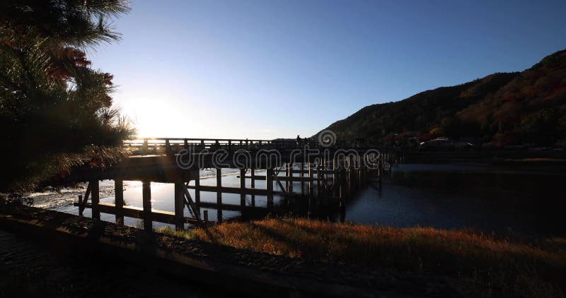 A dawn of Togetsukyo bridge near Katsuragawa river in Kyoto in autumn wide shot