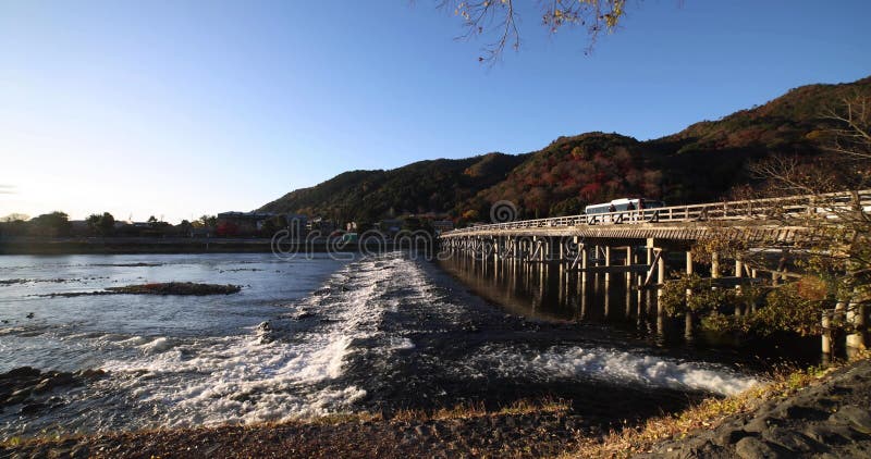 A dawn of Togetsukyo bridge near Katsuragawa river in Kyoto in autumn wide shot