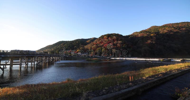 A dawn of Togetsukyo bridge near Katsuragawa river in Kyoto in autumn wide shot