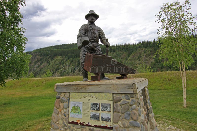 DAWSON STAD, YUKON, KANADA, JUNI 24 2014: Monumentet av gruvarbetaren George Washington Carmack i Dawson City, Kanada på Juni arkivbilder DAWSON STAD, YUKON, KANADA, JUNI 24 2014: Monumentet av gruvarbetaren George Washington Carmack i Dawson City, Kanada på Juni arkivbilder