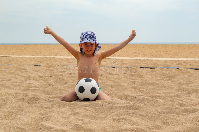 During the day the child plays football on the beach. stock image During the day the child plays football on the beach. stock image