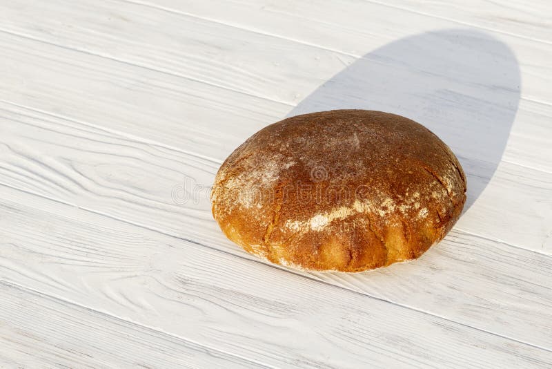 Daylight. rye bread on a white wooden background. Copy space royalty free stock images