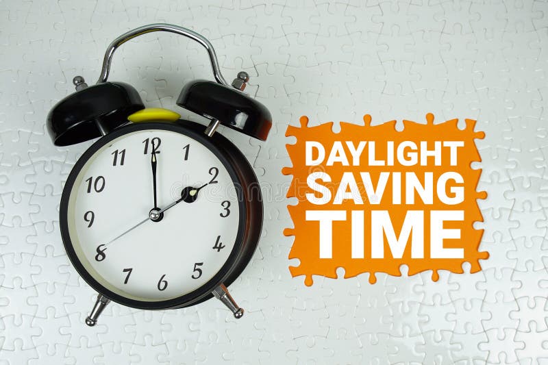 Daylight Saving Time text with alarm clock on orange background royalty free stock photos