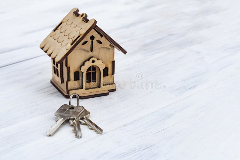 Daylight. the wooden background is painted white. There are keys on it next to a toy house royalty free stock image
