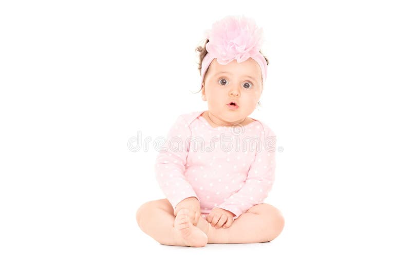 De aanbiddelijke zitting van het babymeisje op de vloer royalty-vrije stock afbeelding De aanbiddelijke zitting van het babymeisje op de vloer royalty-vrije stock afbeelding