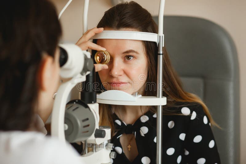 De aantrekkelijke vrouwelijke artsenoftalmoloog controleert de oogvisie van jonge vrouw in moderne kliniek Arts en Patiënt royalty-vrije stock foto De aantrekkelijke vrouwelijke artsenoftalmoloog controleert de oogvisie van jonge vrouw in moderne kliniek Arts en Patiënt royalty-vrije stock foto