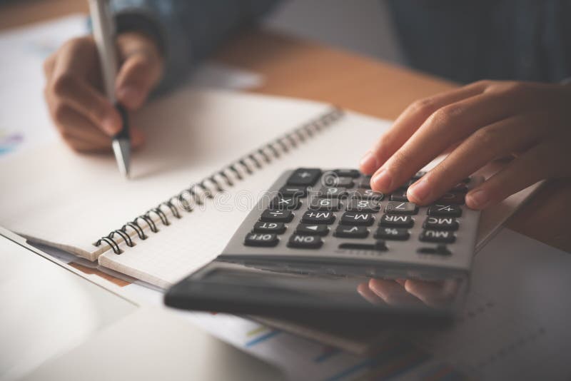 De accountant gebruikt de rekenmachine. voor de analyse van de kosten, de berekening van de winst en het verlies en de belasting