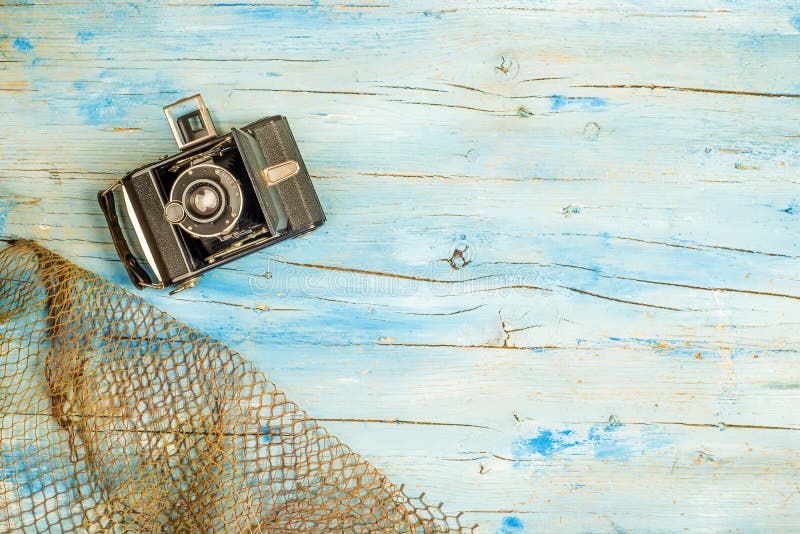 Summer holidays background, old camera and fishing net on rustic blue wooden background with blank space to write text or put photos. Summer holidays background, old camera and fishing net on rustic blue wooden background with blank space to write text or put photos