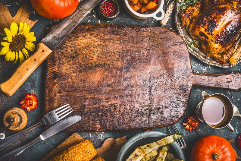 De achtergrond van het dankzeggingsdiner met Turkije, saus, roosterde groenten, graan, bestek, pompoen, arrangemen de de dalingsb stock fotografie De achtergrond van het dankzeggingsdiner met Turkije, saus, roosterde groenten, graan, bestek, pompoen, arrangemen de de dalingsb stock fotografie