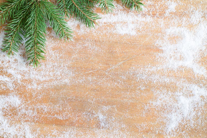 De achtergrond van het Kerstmisbaksel met suiker en spar op scherpe raad