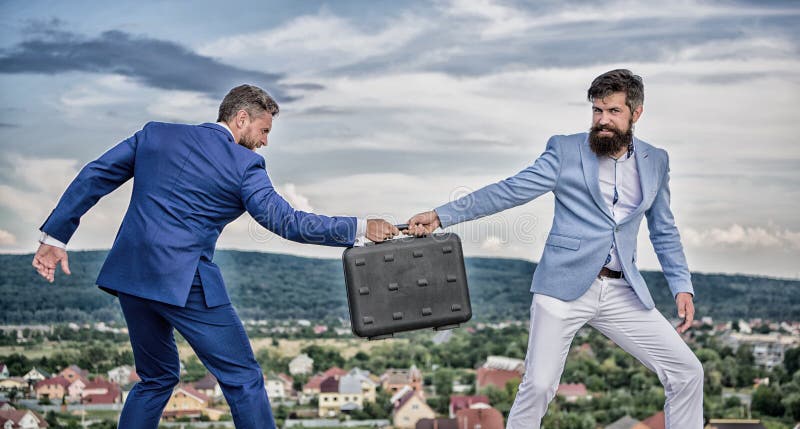 De achtergrond van het transactielandschap De zakenman haalt aktentas van partner weg Fraude en afpersingsconcept stock fotografie De achtergrond van het transactielandschap De zakenman haalt aktentas van partner weg Fraude en afpersingsconcept stock fotografie