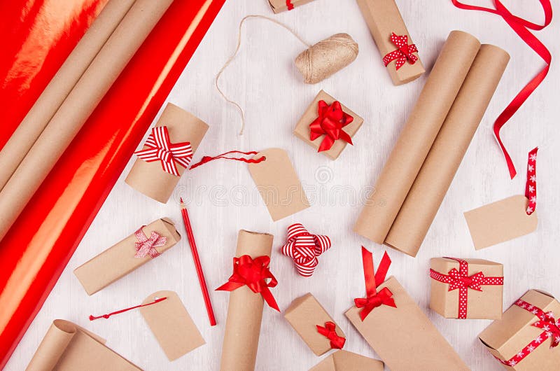 De achtergrond van Kerstmisvoorbereidingen - verpakkend document, giftvakjes, rode lint en bogen, streng als feestelijk patroon o stock foto De achtergrond van Kerstmisvoorbereidingen - verpakkend document, giftvakjes, rode lint en bogen, streng als feestelijk patroon o stock foto