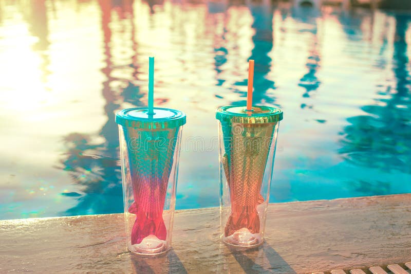 De achtergrond van de strandvakantie met twee cocktails in het glas dichtbij zwembad van de meerminstaart in luxueus hotel royalty-vrije stock afbeeldingen De achtergrond van de strandvakantie met twee cocktails in het glas dichtbij zwembad van de meerminstaart in luxueus hotel royalty-vrije stock afbeeldingen