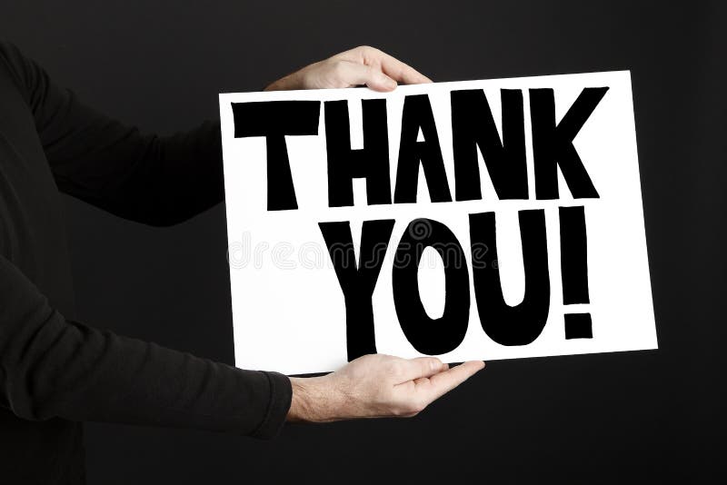 Man holding poster with thank you in front of a black background. Man holding poster with thank you in front of a black background