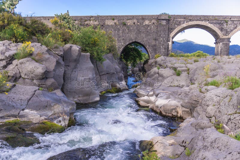 Old stone bridge over River Alcantara near Castiglione di Sicilia village, Sicily in Italy, valley, park, island, italian, republic, isle, nature, landscape, scenic, scenics, scenery, natural, rock, rocks, water, protected, area, reserve, bioreserve, preserve, wilderness, bank, riverside, stones, rocky, stony, high. Old stone bridge over River Alcantara near Castiglione di Sicilia village, Sicily in Italy, valley, park, island, italian, republic, isle, nature, landscape, scenic, scenics, scenery, natural, rock, rocks, water, protected, area, reserve, bioreserve, preserve, wilderness, bank, riverside, stones, rocky, stony, high