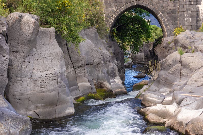 Old stone bridge over River Alcantara near Castiglione di Sicilia village, Sicily in Italy, valley, park, island, italian, republic, isle, nature, landscape, scenic, scenics, scenery, natural, rock, rocks, water, protected, area, reserve, bioreserve, preserve, wilderness, bank, riverside, stones, rocky, stony, high. Old stone bridge over River Alcantara near Castiglione di Sicilia village, Sicily in Italy, valley, park, island, italian, republic, isle, nature, landscape, scenic, scenics, scenery, natural, rock, rocks, water, protected, area, reserve, bioreserve, preserve, wilderness, bank, riverside, stones, rocky, stony, high