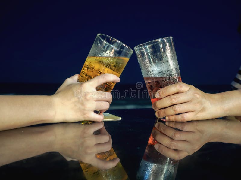 De alcoholviering die van het toejuichingenbier een toost maken bij het strand stock foto's De alcoholviering die van het toejuichingenbier een toost maken bij het strand stock foto's