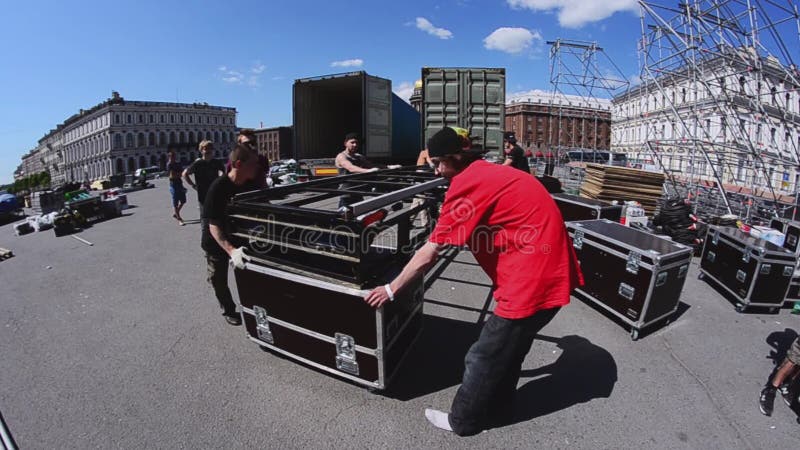 De arbeiders bouwen straatstadium voor de zomergebeurtenis Bewegende bouwtreden aan vrachtwagen