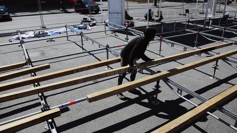 De arbeiders bouwen straatstadium voor gebeurtenis bouw De mens maakt houten raad op