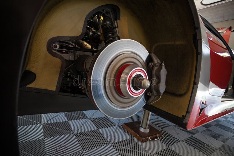 De arbeiders controleren de achterremmen van supercar in de garage royalty-vrije illustratie De arbeiders controleren de achterremmen van supercar in de garage royalty-vrije illustratie