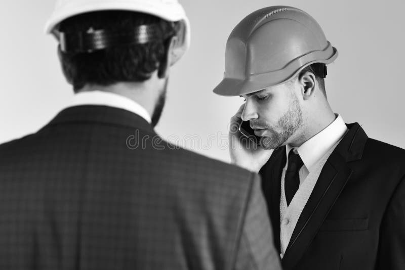 De architecten bespreken project Werknemer met smartphone op commerciële vergadering Bouw, techniek, zaken royalty-vrije stock afbeeldingen De architecten bespreken project Werknemer met smartphone op commerciële vergadering Bouw, techniek, zaken royalty-vrije stock afbeeldingen