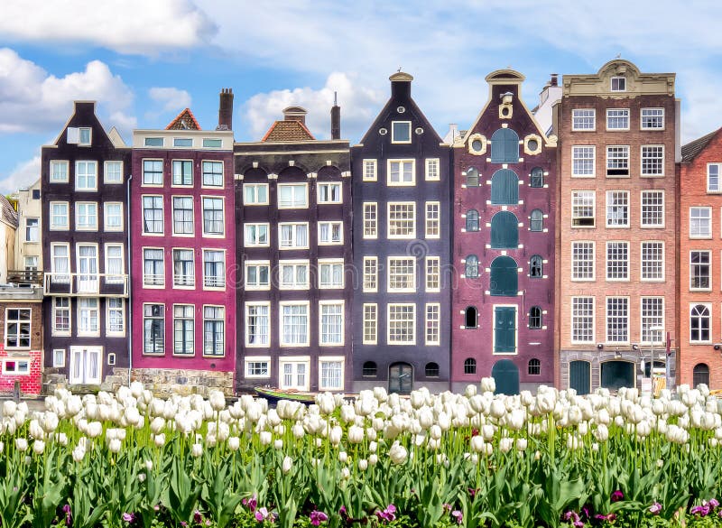 De architectuur van Amsterdam bij het kanaal en de lentetulpen van Damrak, Nederland royalty-vrije stock foto's De architectuur van Amsterdam bij het kanaal en de lentetulpen van Damrak, Nederland royalty-vrije stock foto's