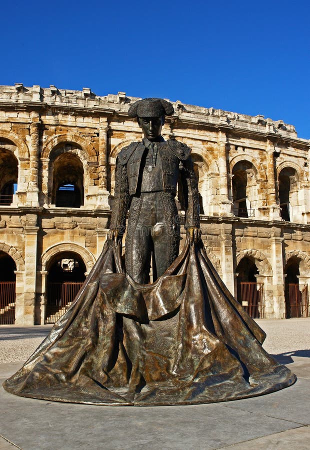 Bullfighter statue with Arena of Nimes bullring in background, Nimes, France. Bullfighter statue with Arena of Nimes bullring in background, Nimes, France.