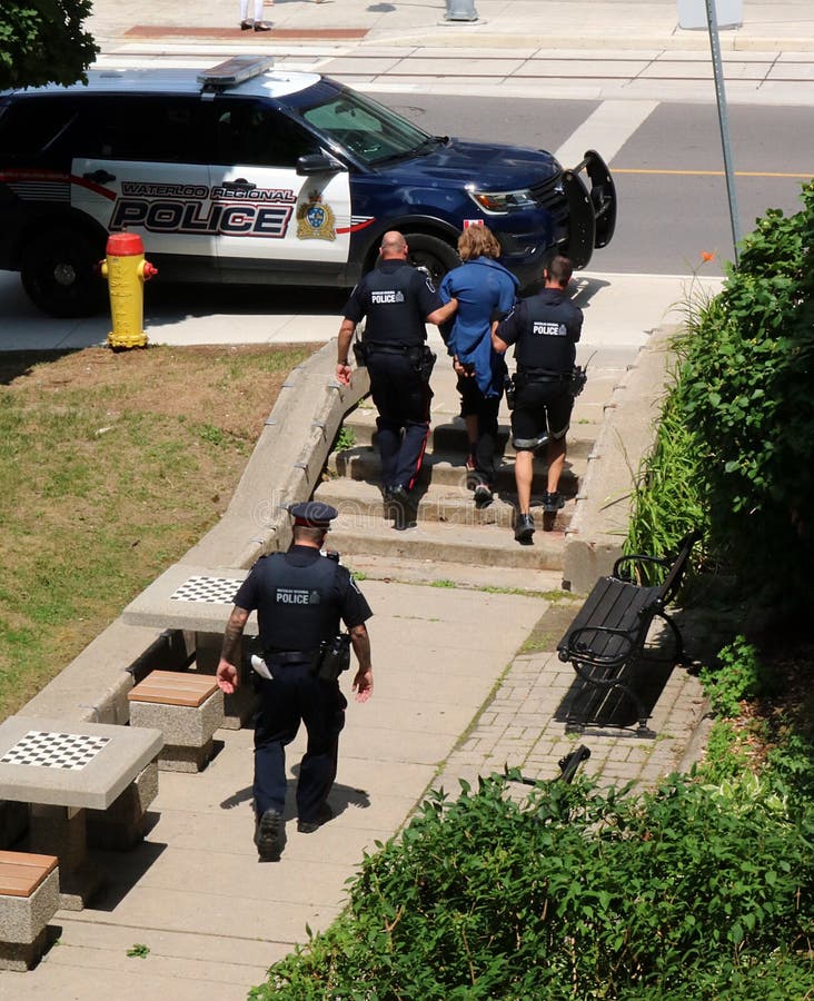 De arrestant van de politieescorte aan auto in Kitchener, Waterloo, Ontario stock fotografie De arrestant van de politieescorte aan auto in Kitchener, Waterloo, Ontario stock fotografie