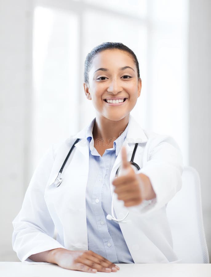Healthcare and medical concept - african doctor with stethoscope showing thumbs up. Healthcare and medical concept - african doctor with stethoscope showing thumbs up