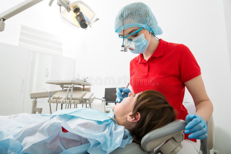 De artsentandarts behandelt tanden van een vrouwelijke patiënt De vrouw op ontvangst bij de tandarts van tandartsDoctor behandelt royalty-vrije stock fotografie De artsentandarts behandelt tanden van een vrouwelijke patiënt De vrouw op ontvangst bij de tandarts van tandartsDoctor behandelt royalty-vrije stock fotografie