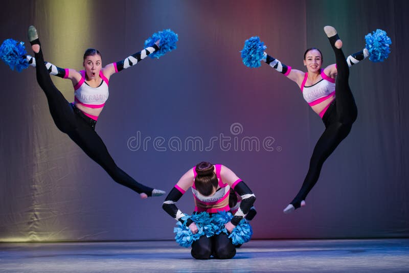 De atleten presteren op stadium, presteren jonge cheerleaders bij het cheerleading kampioenschap, meisjes in een sprong, meisje a royalty-vrije stock foto De atleten presteren op stadium, presteren jonge cheerleaders bij het cheerleading kampioenschap, meisjes in een sprong, meisje a royalty-vrije stock foto