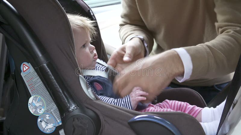 De Auto Seat van vaderputting baby into