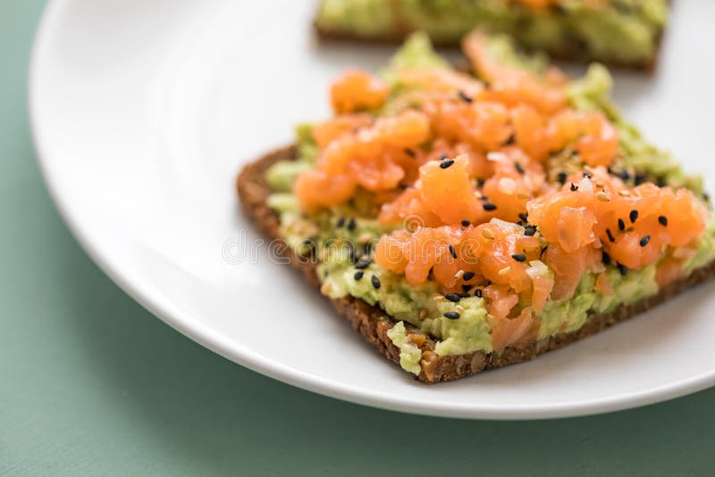 De avocado rookte zalm op plak van het de korrelbrood van het zonnebloemzaad de gehele met sesamzaden voor ontbijt of snack op mu royalty-vrije stock foto's De avocado rookte zalm op plak van het de korrelbrood van het zonnebloemzaad de gehele met sesamzaden voor ontbijt of snack op mu royalty-vrije stock foto's