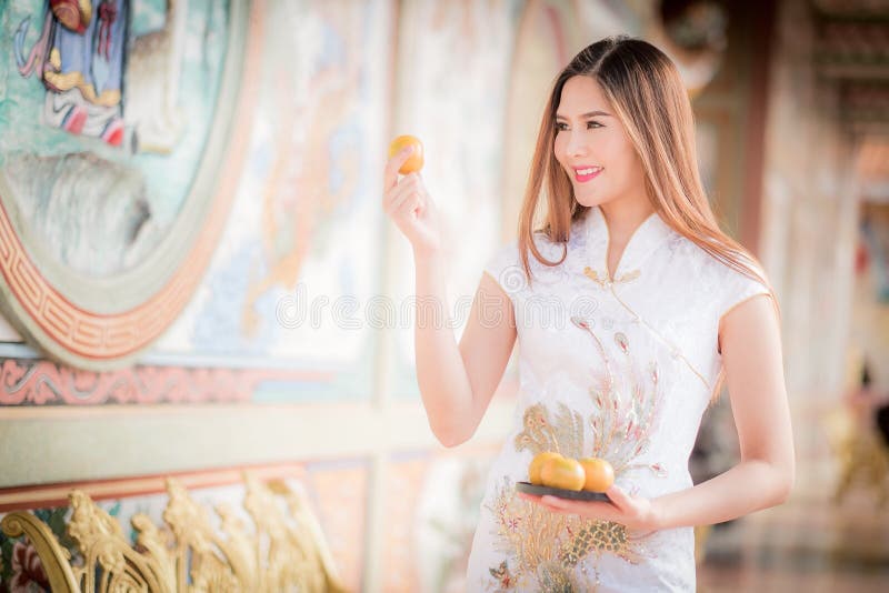 De Aziatische Chinese vrouw in Traditionele Chinese holdingssinaasappel betaalt aangaande royalty-vrije stock fotografie De Aziatische Chinese vrouw in Traditionele Chinese holdingssinaasappel betaalt aangaande royalty-vrije stock fotografie