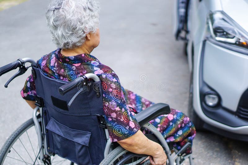 De Aziatische hogere of bejaarde damevrouw de geduldige zitting op rolstoel voorbereidt krijgt aan haar auto: gezond sterk medisc