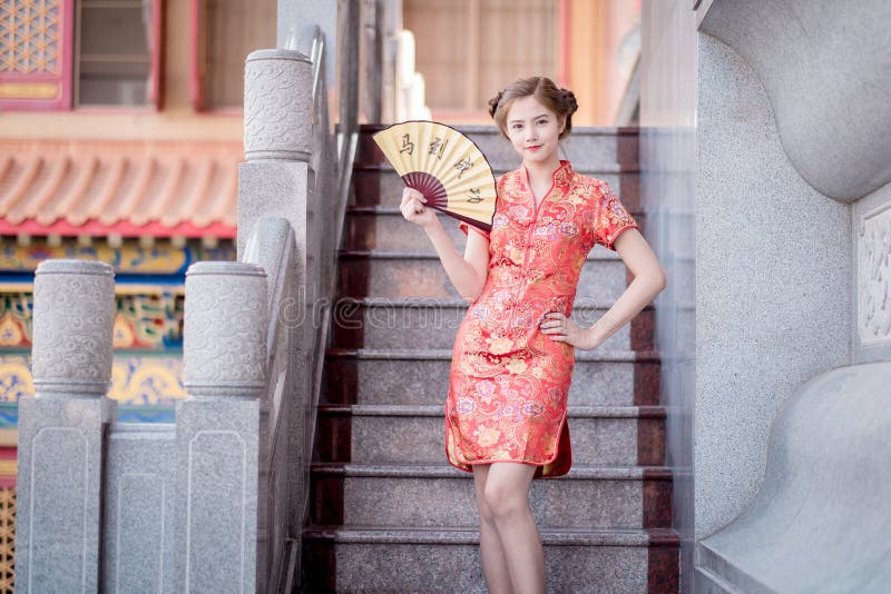 De Aziatische vrouw in het Chinese couplet 'succes' van de kledingsholding (Kin royalty-vrije stock fotografie De Aziatische vrouw in het Chinese couplet 'succes' van de kledingsholding (Kin royalty-vrije stock fotografie