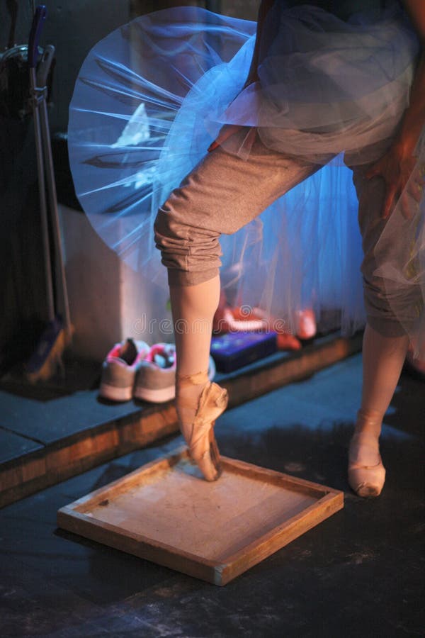 The ballerina rubs the toe of pointe shoes in a box with pounded rosin to prevent slipping. The ballerina rubs the toe of pointe shoes in a box with pounded rosin to prevent slipping