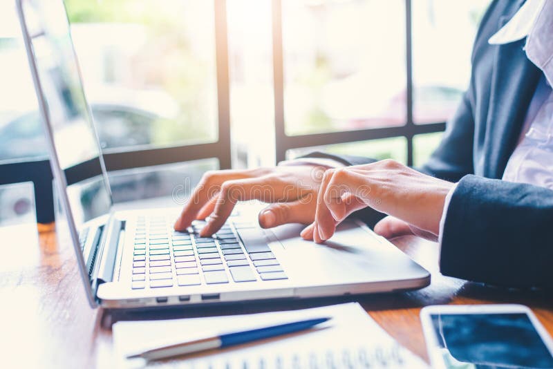 De bedrijfsvrouwenhand werkt aan een laptop computer in een bureau stock afbeelding De bedrijfsvrouwenhand werkt aan een laptop computer in een bureau stock afbeelding