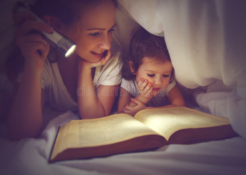 De bedtijd van de familielezing Mamma en kindlezingsboek met een flashl