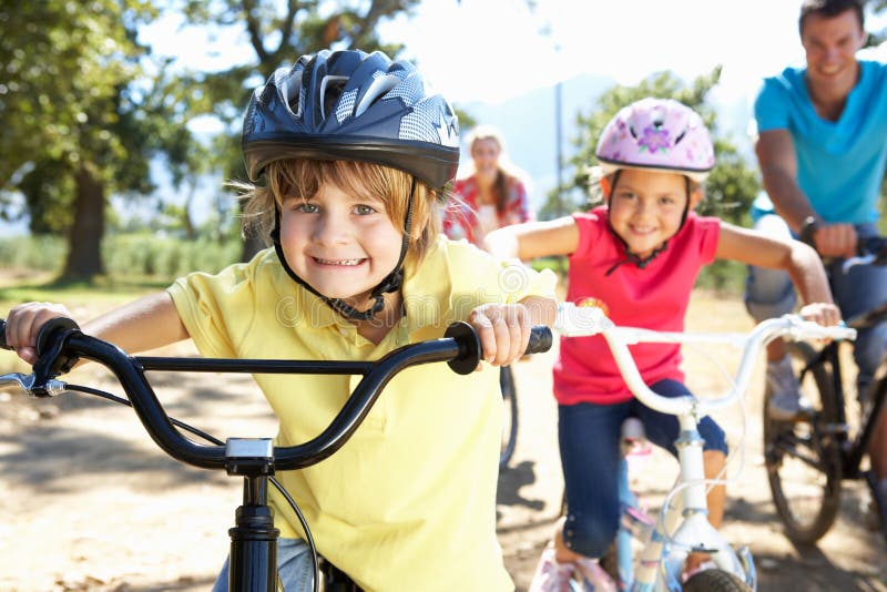 De berijdende fietsen die van de familie pret hebben stock foto's De berijdende fietsen die van de familie pret hebben stock foto's