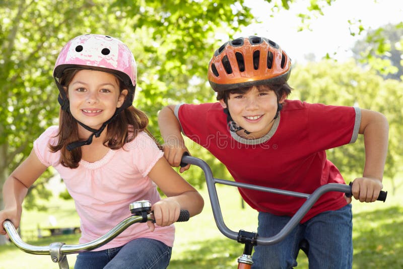 De berijdende fietsen van de jongen en van het meisje stock fotografie De berijdende fietsen van de jongen en van het meisje stock fotografie