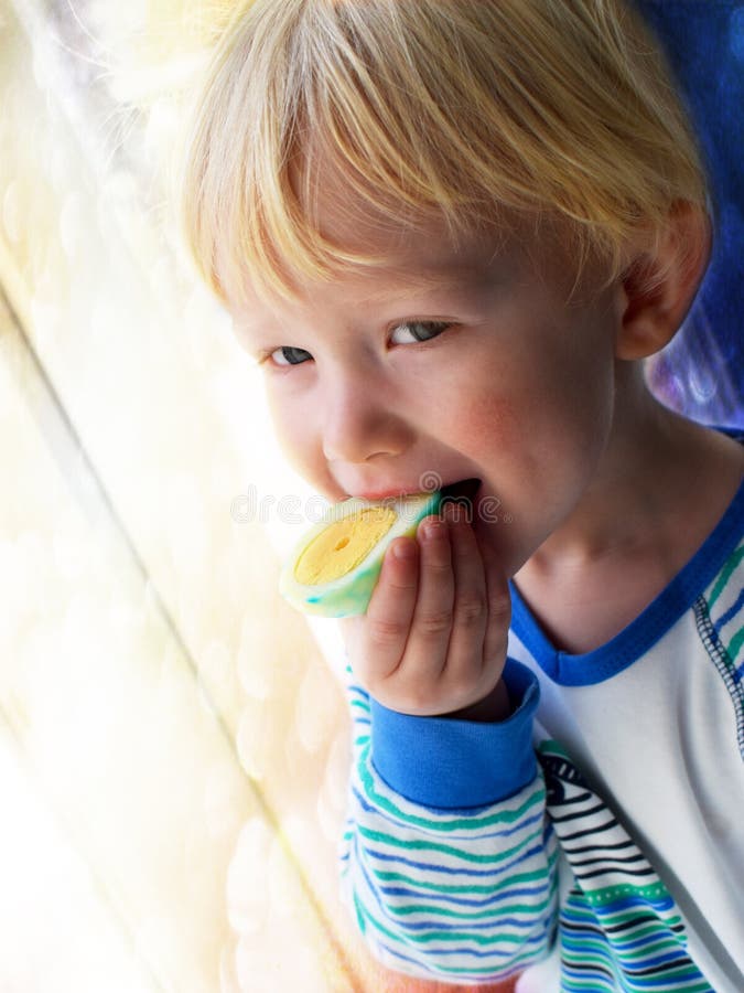 De betenpaasei van de blondebaby voor ontbijt stock fotografie De betenpaasei van de blondebaby voor ontbijt stock fotografie
