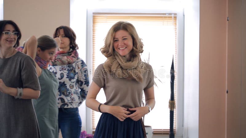 De blonde vrouw bindt sjaal op stijlles binnen studio stock videobeelden